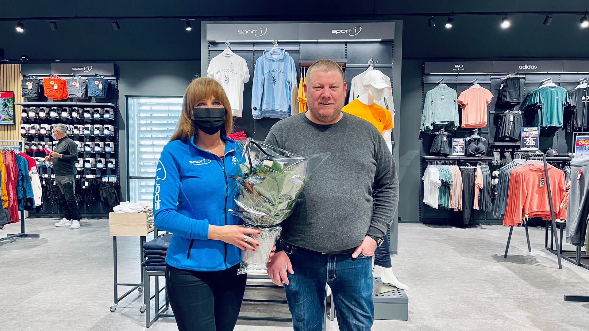 To personer som har fått blomster i nye Amundsen Sport sine lokaler