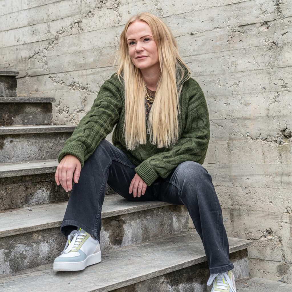 Linn Iddberg sitter i en trapp i ført høstens jeans